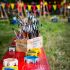 Bunte Malstation mit Pinseln und Farbtöpfen auf einem roten Tisch im Park.