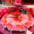 Veganer Karottenkuchen mit Zuckerguss und Marzipanmöhren in einer Kuchenvitrine.